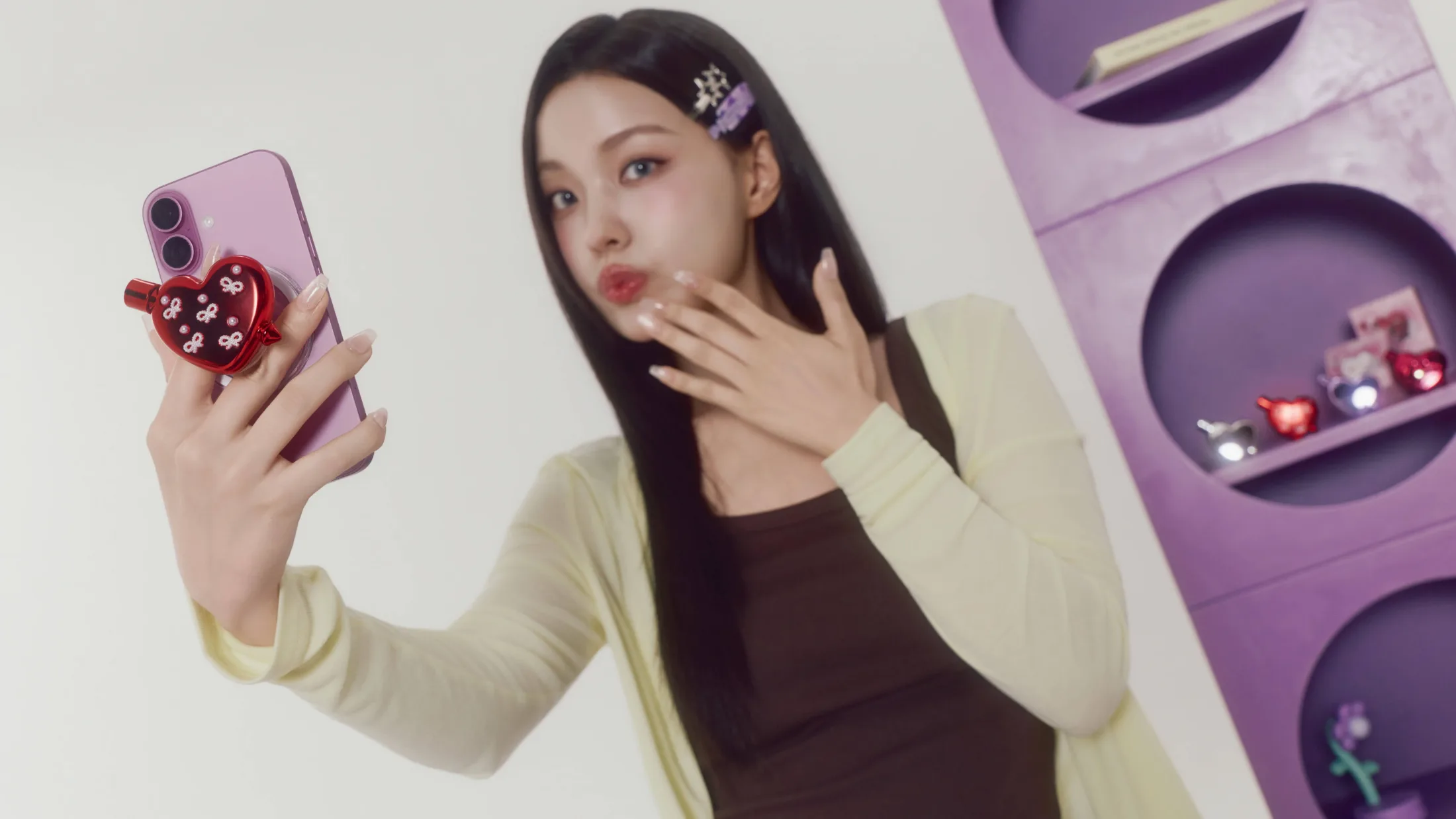하트 틴트를 붙인 휴대폰으로 셀카를 찍는 모습